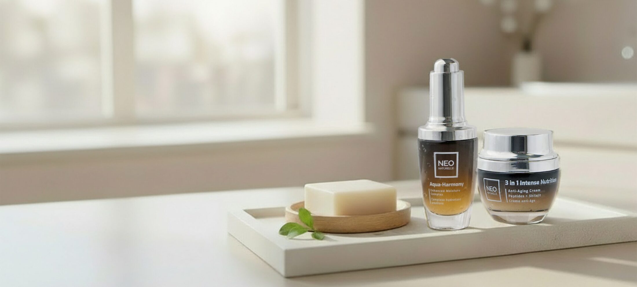 NeoNaturelle skincare products on a stone tray in a soft, sunlit spa-style bathroom setting.